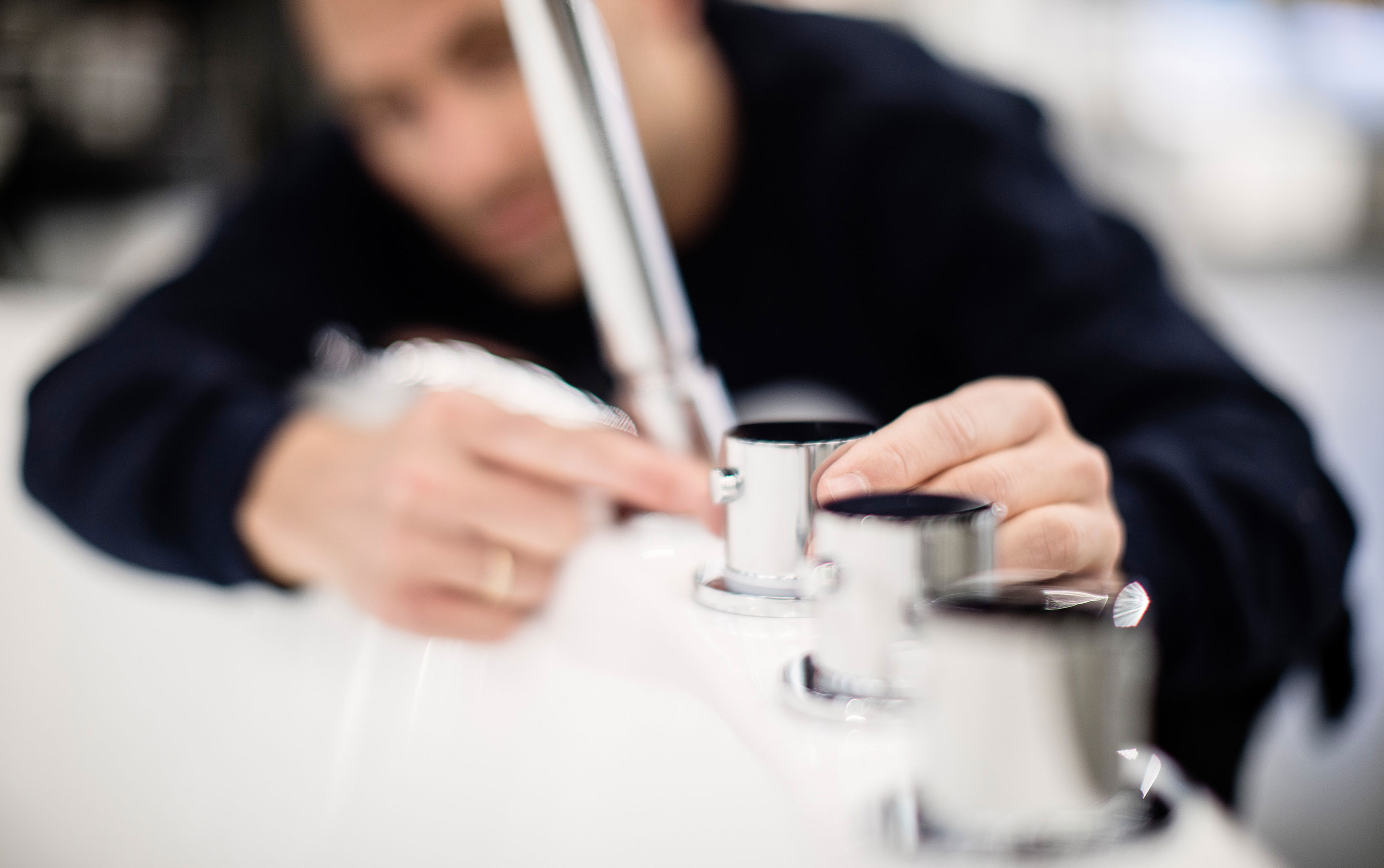 Rørlegger fra Johansen VVS skrur på et badekarbatteri